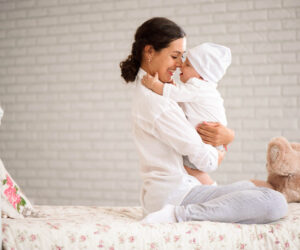 Mother, playing with her toddler boy smiling.